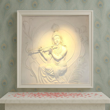 Intricately crafted white marble-finish wall mural depicting Lord Krishna playing the flute, surrounded by peacock feathers and floral motifs, radiating divine serenity in a framed setting.