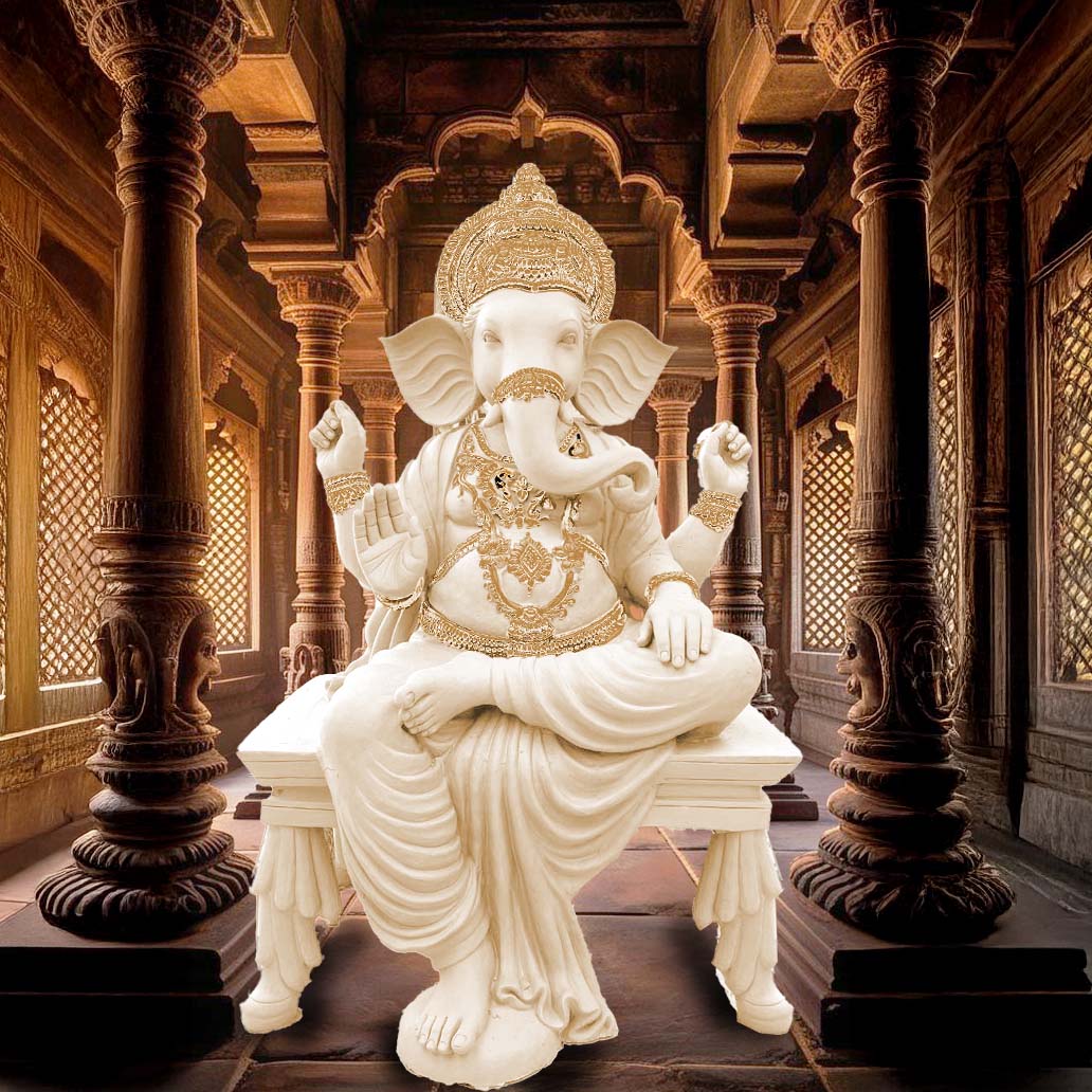 Intricately crafted Lord Ganesha sculpture in white finish with golden detailing, seated on a decorative pedestal inside a traditional Indian temple-style interior.