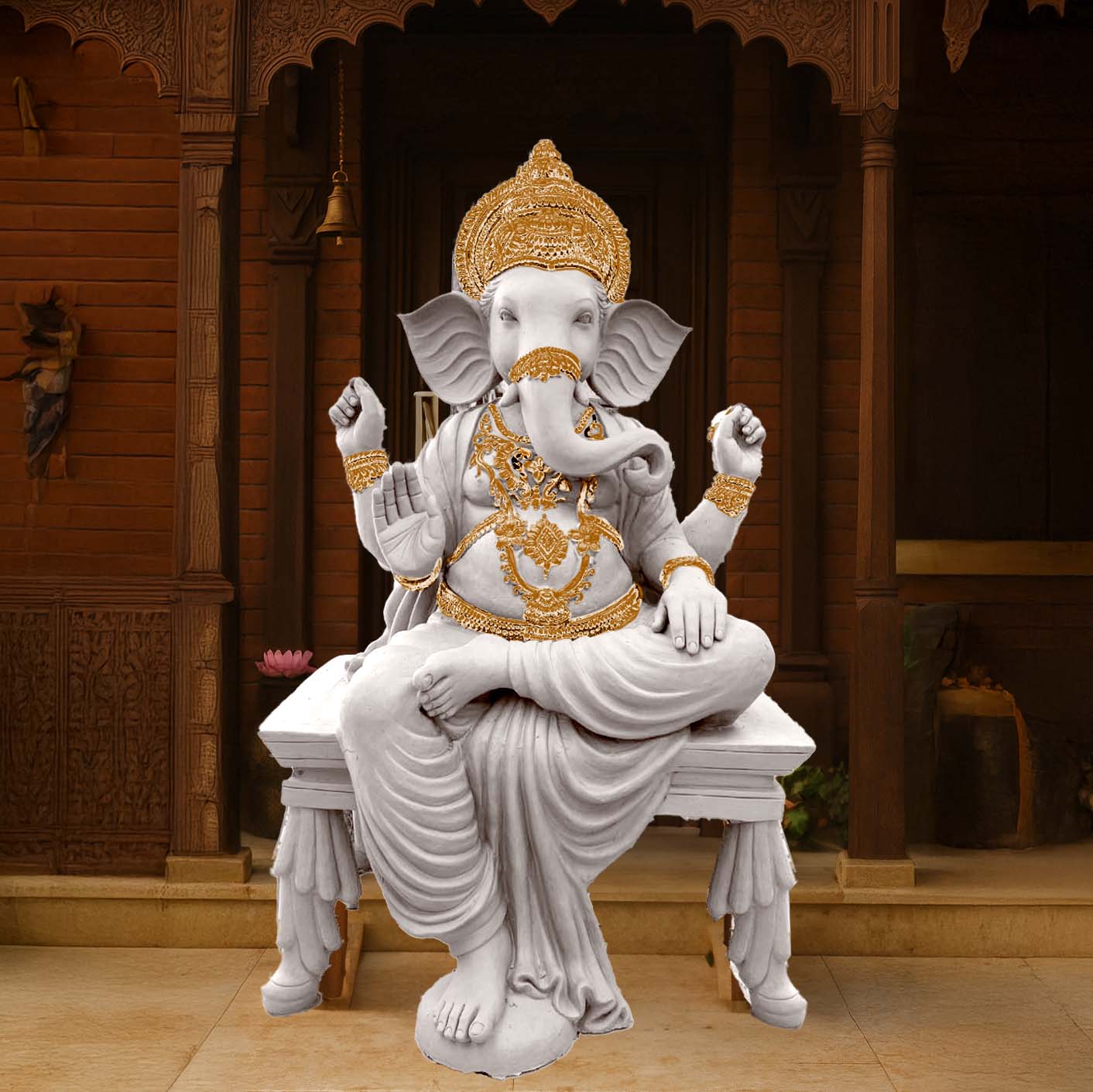 Majestic Lord Ganesha idol in white marble finish with intricate golden ornaments, seated on a decorative pedestal in front of a traditional carved wooden temple backdrop.