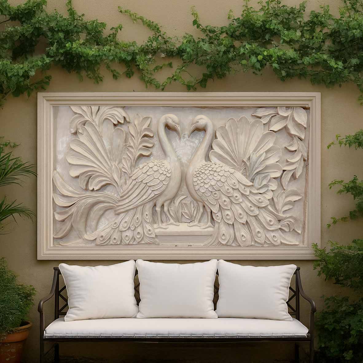 Intricately carved beige stone-finish wall mural depicting two peacocks facing each other with detailed feathers, framed in a rectangular panel and displayed in an elegant outdoor garden seating area.