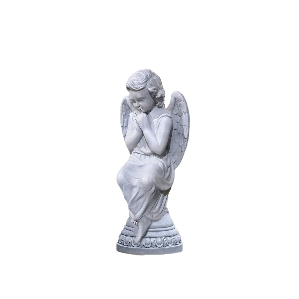 Beautiful praying angel sculpture in a smooth marble finish, with delicate wings and serene detailing, placed indoors in a luxury white-paneled interior.