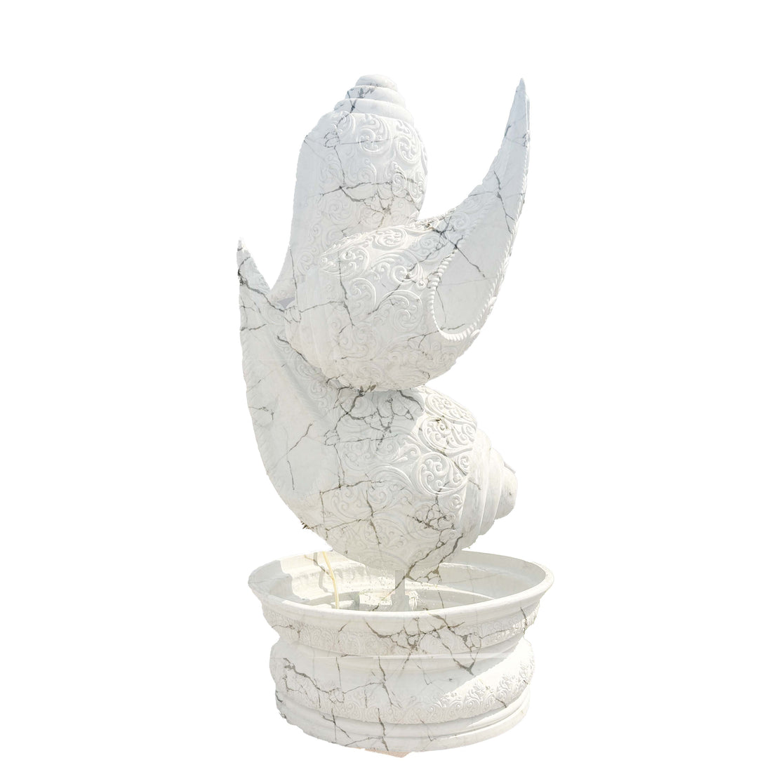 Intricately carved white marble-finish shankh (conch shell) fountain sculpture with detailed textures, placed on a pedestal basin in a luxury garden entrance setting.