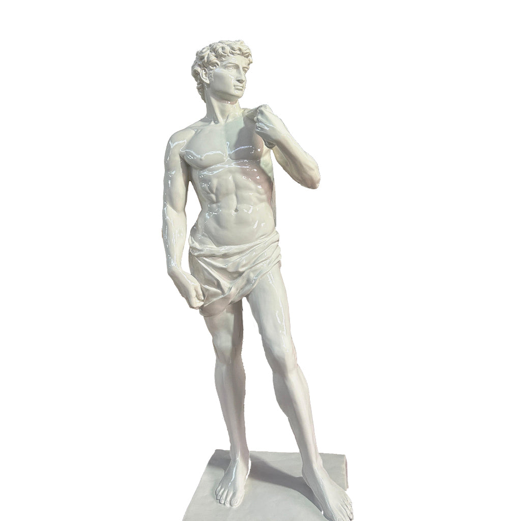 Elegant white glossy finish sculpture inspired by Michelangelo’s David, displayed in a luxurious outdoor courtyard with grand pillars and landscaped greenery.